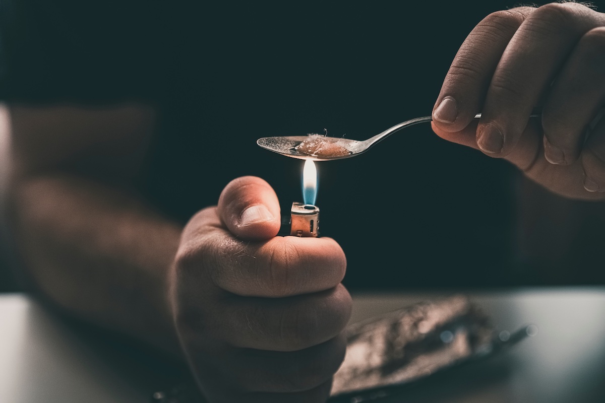 Addict at the table with a syringe heroin addiction