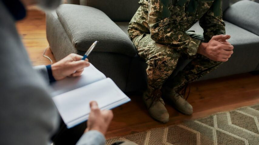 Cropped shot of military man during therapy session with psychologist in Indiana