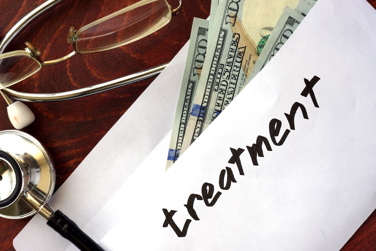 Treatment written on an envelope with dollars