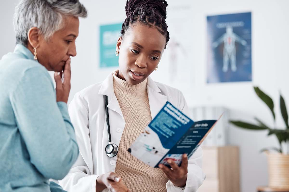 a doctor talking to patient explaining what’s covered under her health insurance for SUD treatment and rehab
