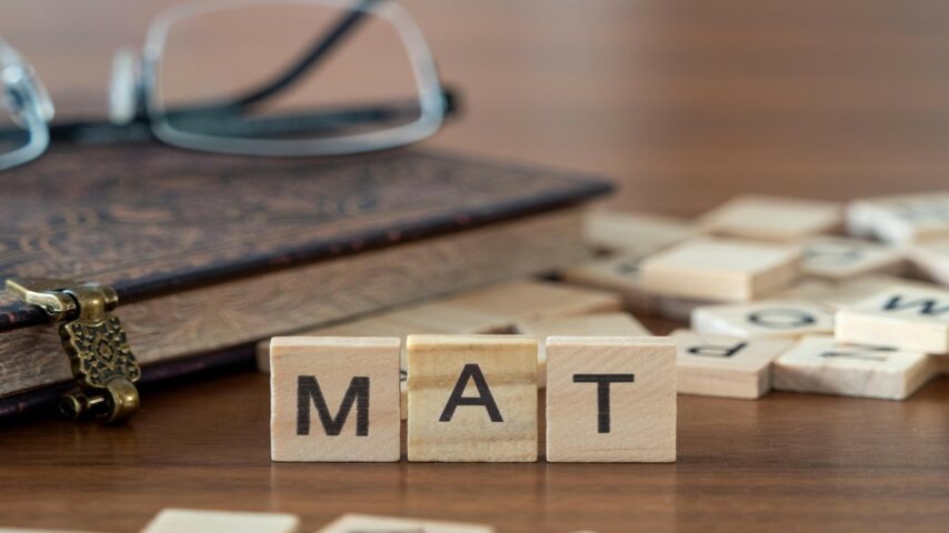 The acronym MAT for medication-assisted treatment concept represented by wooden letter tiles