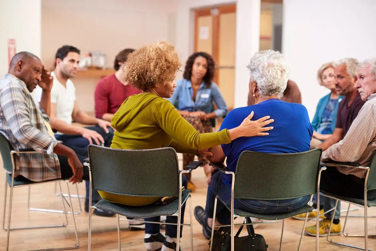 People attending group therapy session for drug addiction in a rehab center