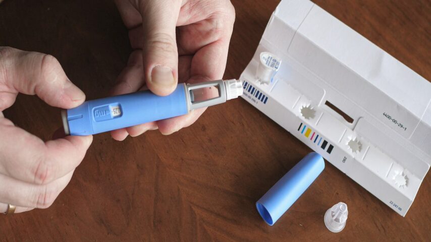obese fat man preparing A man holding a Semaglutide Ozempic injection to control blood sugar levels