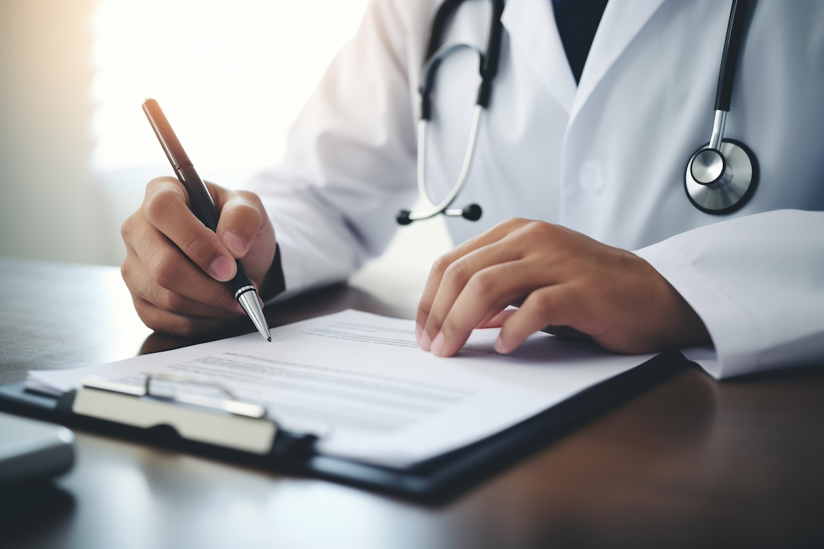 Male doctor signs Priority Health insurance document