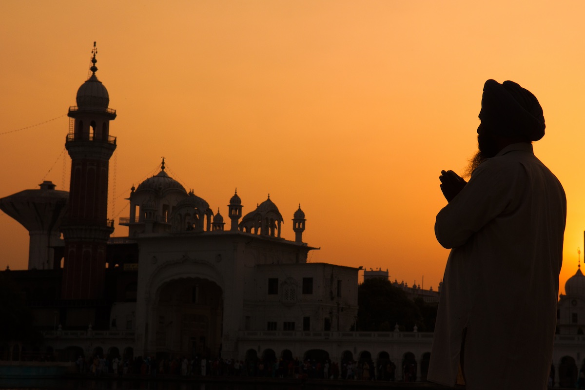 silhouette of sikh pilgrim praying at the holy temple for his addiction recovery journey